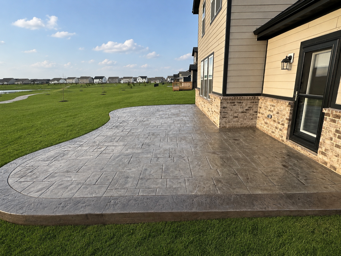 Broom-finished backyard concrete patio with a picture-frame border