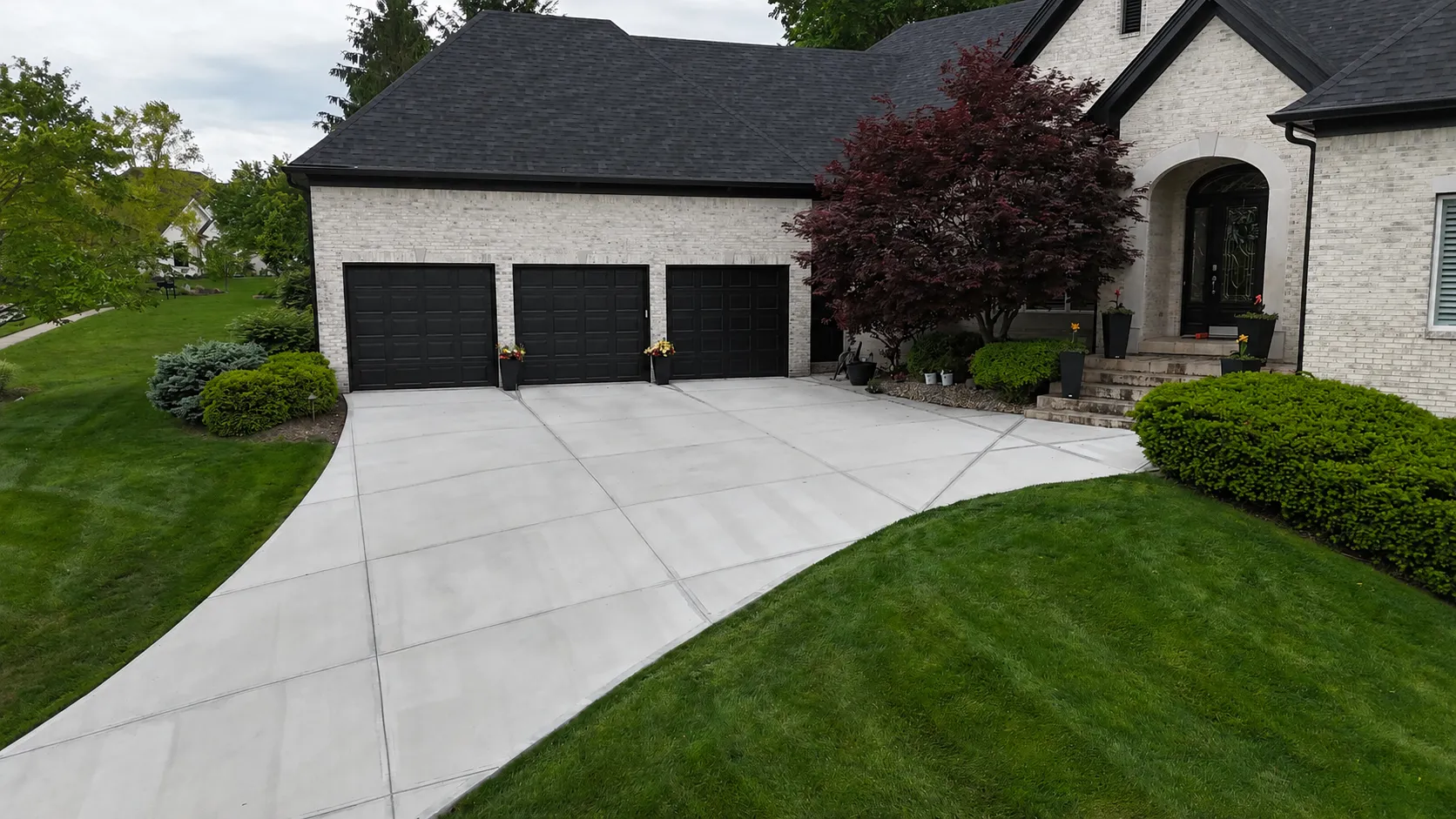 Before and after concrete driveway replacement at an Indianapolis home