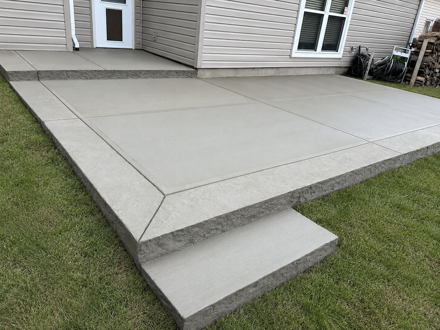 Broom-finished concrete patio with a picture-frame border and control joints